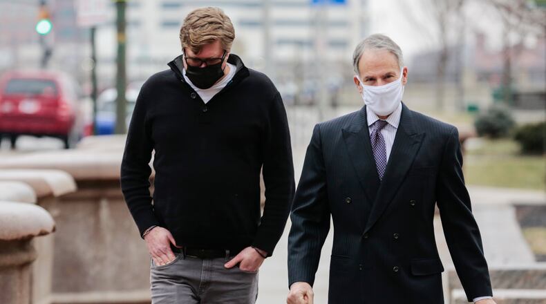 Dustin Thompson, left, of Columbus, who is accused of being part of the Jan. 6 insurrection at the U.S. Capitol, arrives with his lawyer, Sam Shamansky, to turn himself in on Monday, Jan. 25, 2021, at the Joseph P. Kinneary U.S. District Courthouse in Columbus, Ohio. (Joshua A. Bickel/The Columbus Dispatch via AP)