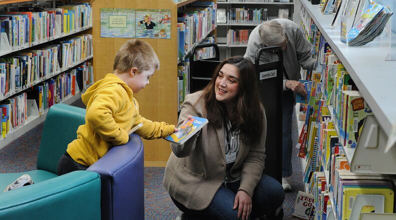 Wesley Smallwood, 6, gets help picking out a book from Head Librarian, Jessica Winegarner, middle, and Library Aide, Joan Taylor at the Fairborn Community Library Thursday, April 28, 2022. MARSHALL GORBY\STAFF
