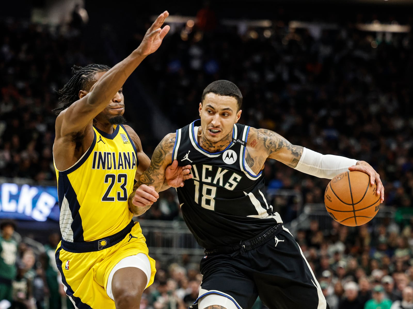 Milwaukee Bucks' Kyle Kuzma (18) drives against the Indiana Pacers' Aaron Nesmith (23) during the first half of Game 4 of a first-round NBA basketball playoff series Sunday, April 27, 2025, in Milwaukee. (AP Photo/Jeffrey Phelps)