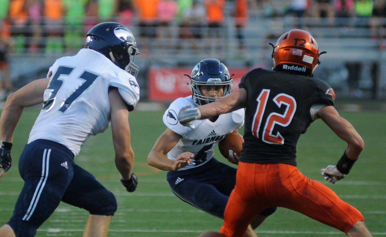 Fairmont’s Kennon Burroughs (with ball) looks for a block by teammate Caleb Smith on Beavercreek’s Jake Maloney. Beavercreek defeated visiting Fairmont 14-3 in a GWOC National East high school football opener on Friday, Sept. 22, 2017. MARC PENDLETON / STAFF