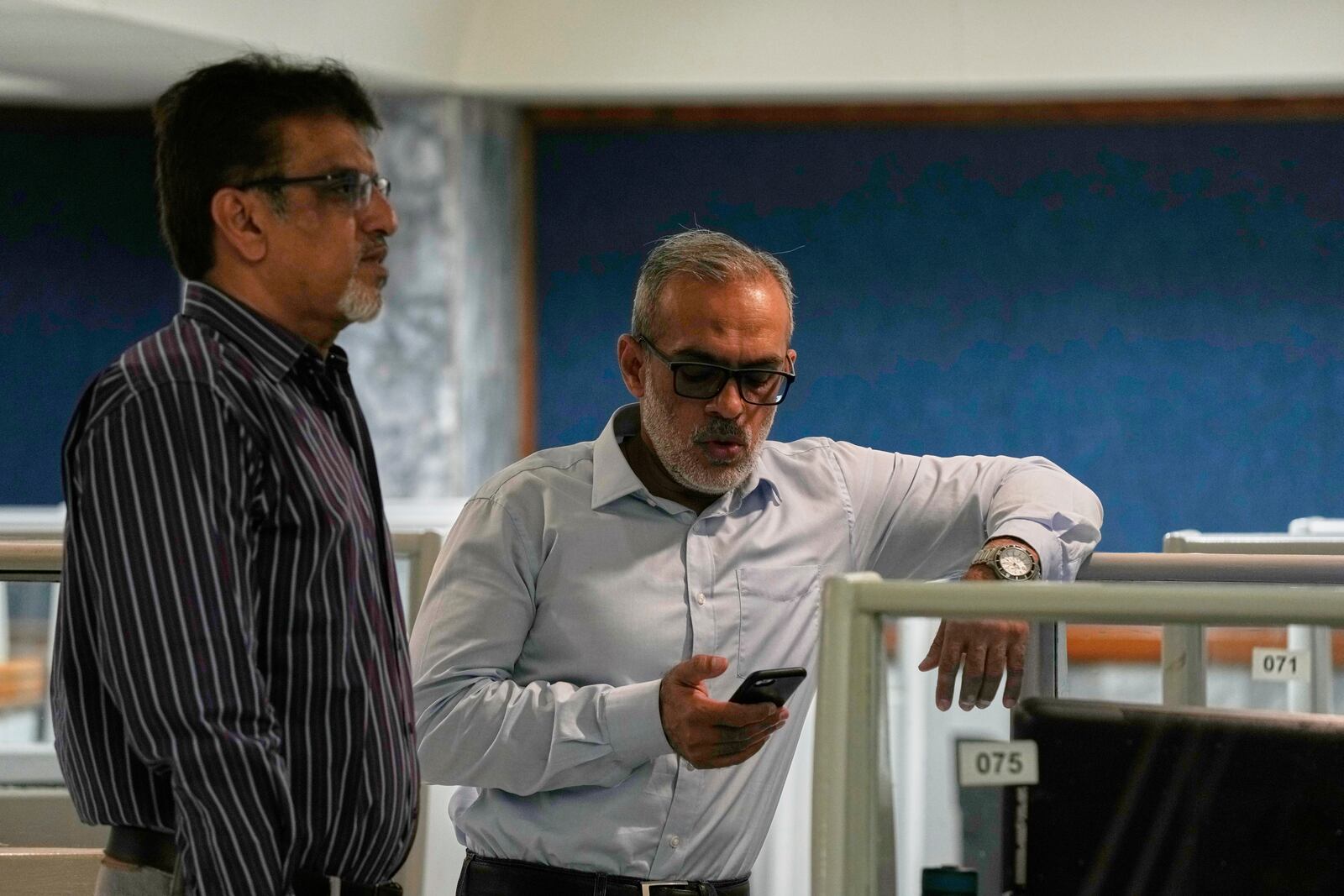 Stock brokers discuss the situation at the Pakistan Stock Exchange (PSE), after trading suspended for an hour following a 5% drop in in its main index, in Karachi, Pakistan, Monday, April 7, 2025. (AP Photo/Fareed Khan)