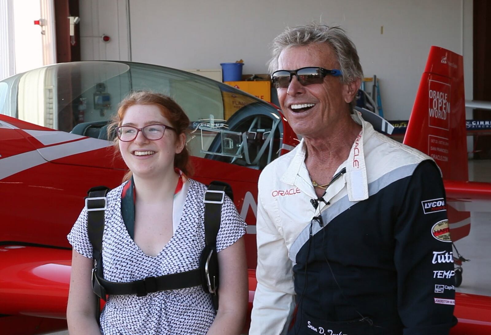 Dayton Air Show Young Eagles essay contest winner Kayla Hughes, 14,  and legendary pilot Sean D. Tucker at the Piqua Airport.  Hughes' originally scheduled flight was cancelled due to poor weather days before the Dayton Air Show in June but Tucker found a way to make it happen on Tuesday in Piqua.   TY GREENLEES / STAFF