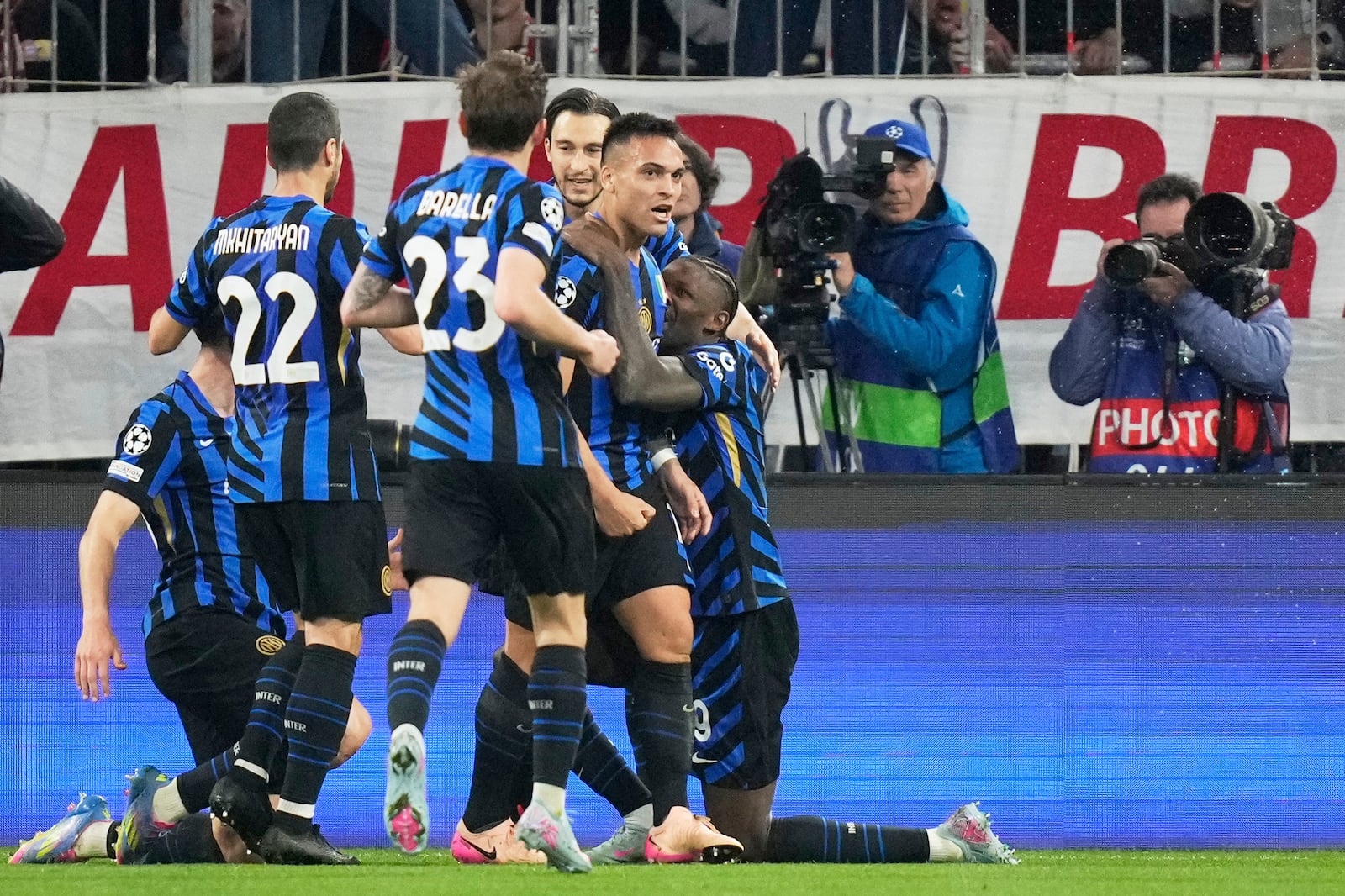 Inter Milan's Lautaro Martinez, center, celebrates with teammates after scoring opening goal during the Champions League quarterfinals first leg soccer match between FC Bayern Munich and Inter Milan, at the Allianz Arena in Munich, Germany, Tuesday, April 8, 2025. (AP Photo/Matthias Schrader)