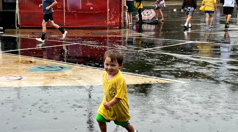 While some attendees to AlterFest on Saturday sought shelter from the rain under tents and umbrellas, Ari Lauwers, 2, relished in it. AIMEE HANCOCK/STAFF