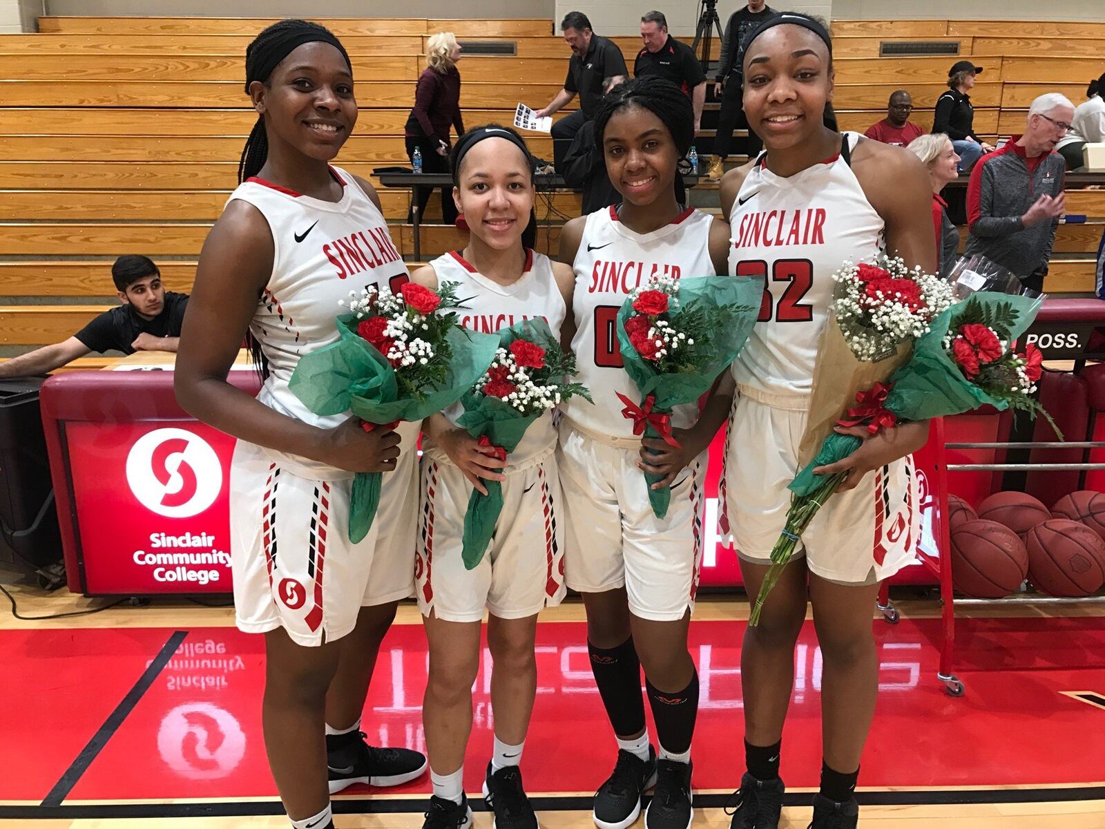 Sinclair’s four sophomores — from left: Aaryn Evans, Nia Martin, Laquelle Jacobs, Madison Connally-Banks) — were honored on the court after the last home game of their junior college careers Saturday. Tom Archdeacon/STAFF