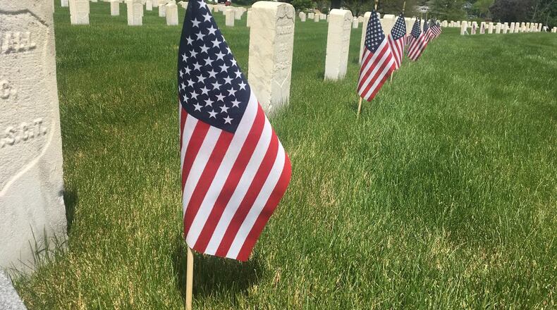 Some graves had flags placed next to them on Memorial Day, but others did not due to the coronavirus pandemic. STAFF/ PARKER PERRY