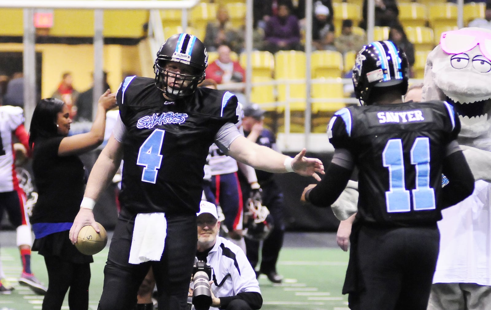 Dayton Sharks quarterback and Eaton grad Tommy Jones (4) welcome Evan Sawyer (11) during opening ceremonies 
during the CIFL Dayton Sharks inaugural home game in February of 2015 at Hara Arena. CHARLES CAPERTON / CONTRIBUTED PHOTO