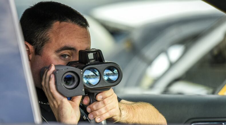New Miami Police officer Mark Bennett uses a photo speed enforcement camera along US 127. NICK GRAHAM/STAFF