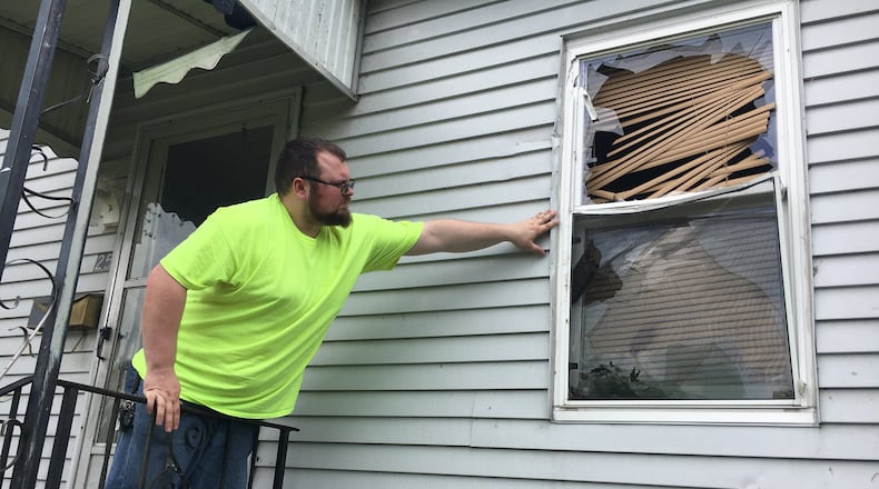 Michael Santana assesses damage to his home at the Overlook Houses in Riverside after a Memorial Day tornado threw a branch through his walls. STAFF PHOTO / HOLLY SHIVELY