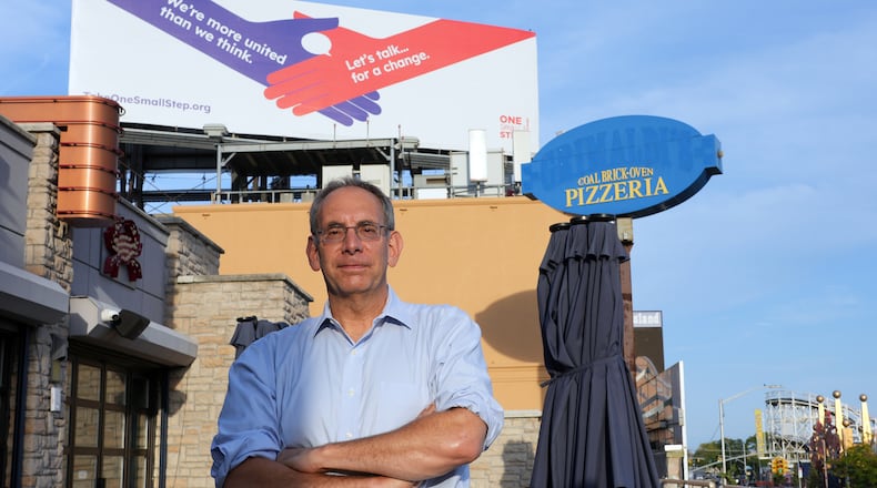 Dave Isay, the founder of StoryCorps, in front of a billboard in Brooklyn advertising the One Small Step initiative, Sept. 17, 2024. One Small Step, an initiative that facilitates conversations between people with opposing views, is trying to tackle political polarization. (Michelle V. Agins/The New York Times)