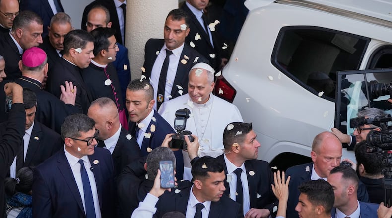 Rose petals are scattered to Pope Leo XIV as he leaves after visiting the Psychiatric Hospital of the Cross in the town of Jal el-Dib, north of Beirut, Lebanon, Tuesday, Dec. 2, 2025. (AP Photo/Hassan Ammar)