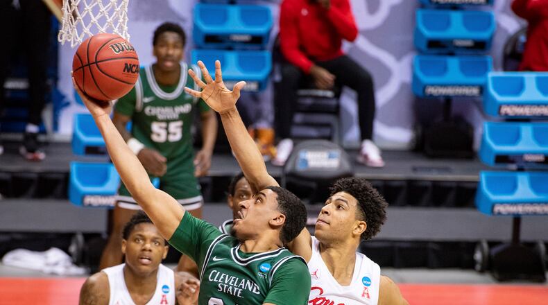 Cleveland State guard Torrey Patton (24), left, slips around the defense of Houston guard Quentin Grimes (24) to score during the first half of a first-round game in the NCAA men's college basketball tournament, Friday, March 19, 2021, at Assembly Hall in Bloomington, Ind. (AP Photo/Doug McSchooler)