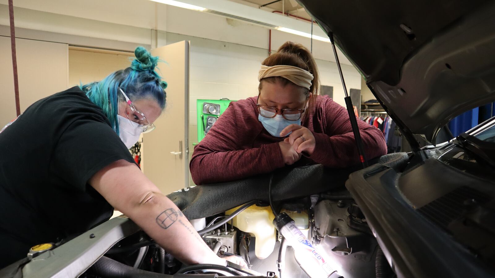 Hanna Weaver (right) helps a student remove a serpentine belt. Contributed