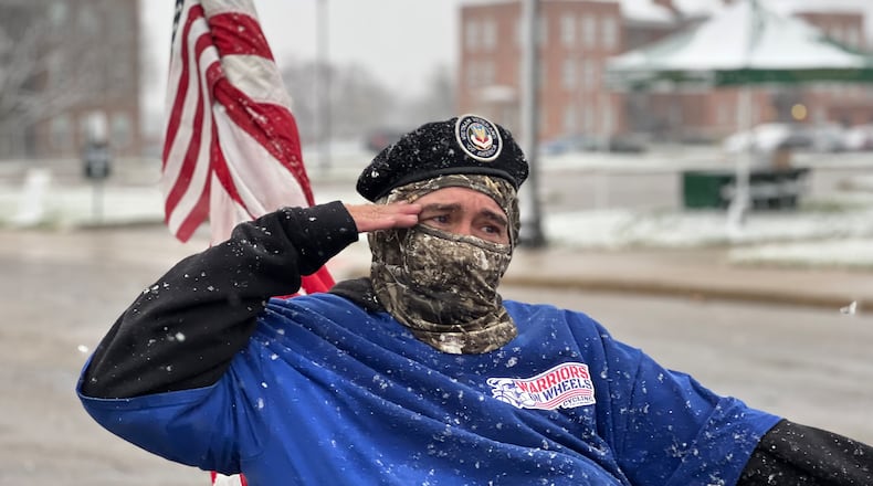 A veteran and parade participant salutes fellow vets in attendance during Saturday's event at the Dayton VA Medical Center campus. AIMEE HANCOCK/STAFF