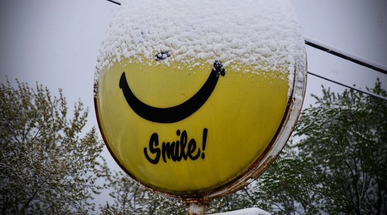 This sign near Fairborn says smile, even though half of it is covered with snow on Wednesday, April 21, 2021. MARSHALL GORBY\STAFF