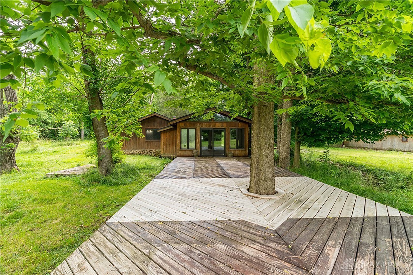 The sunroom over looks an extra large deck that looks over the woods and a creek.