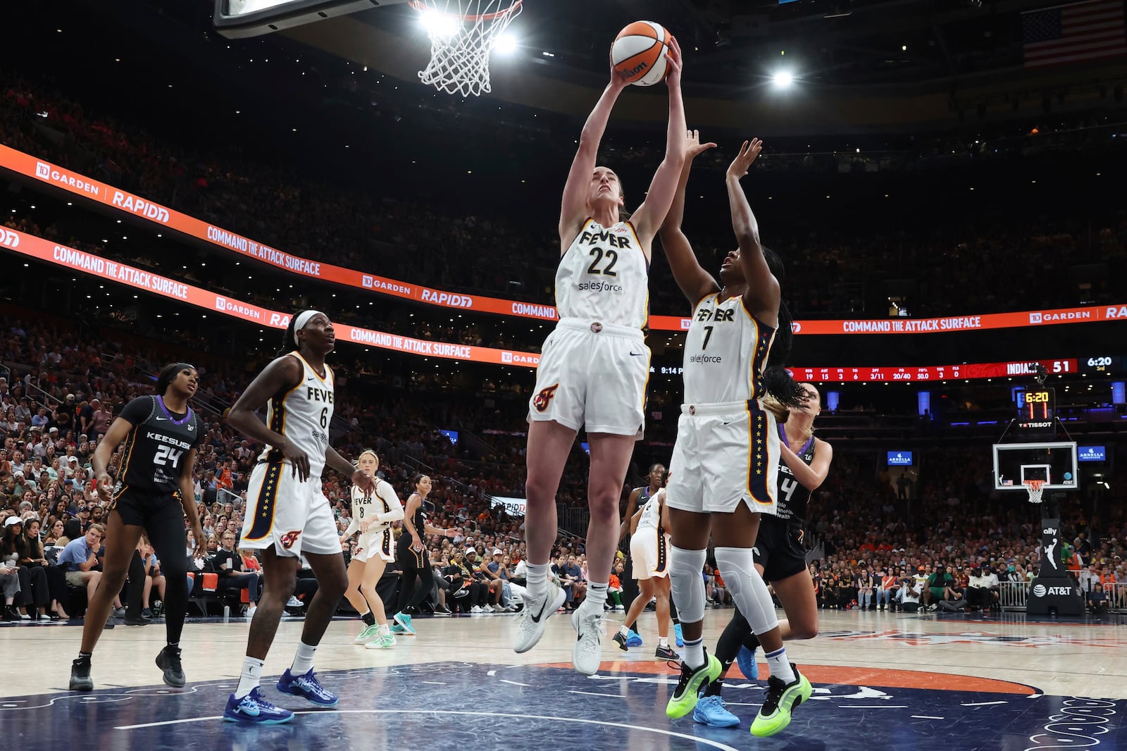 Indiana Fever's Caitlin Clark (22) grabs a rebound beside teammate Aliyah Boston (7) during the second half of a WNBA basketball game against the Connecticut Sun, Tuesday, July 15, 2025, in Boston. (AP Photo/Michael Dwyer)