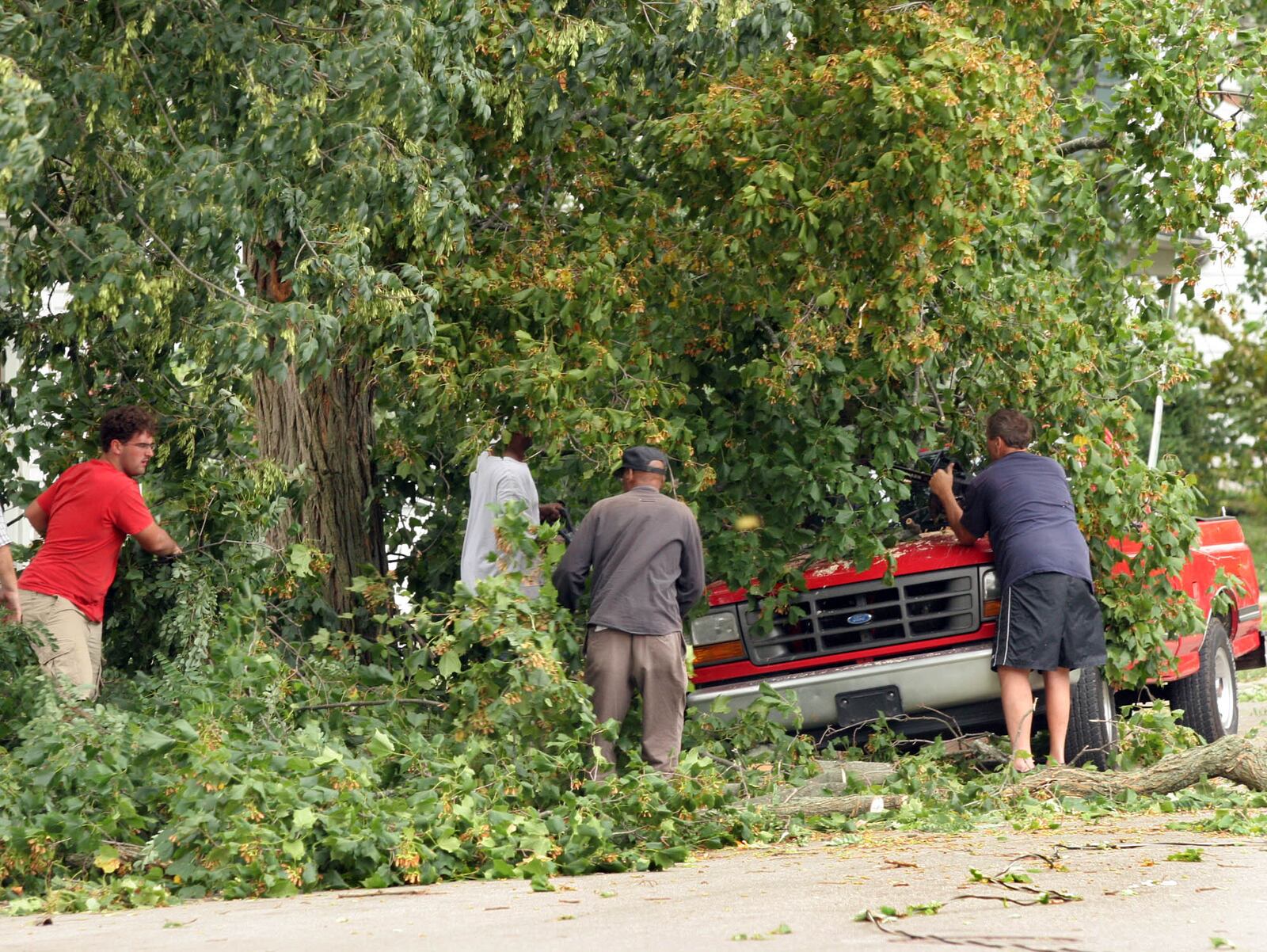 Tree branches are removed from atop a pick-up truck along Short St. in Troy Sunday afternoon. Severe winds from Hurricane Ike caused heavy damage across the entire Miami Valley. Staff photo by Jim Witmer
