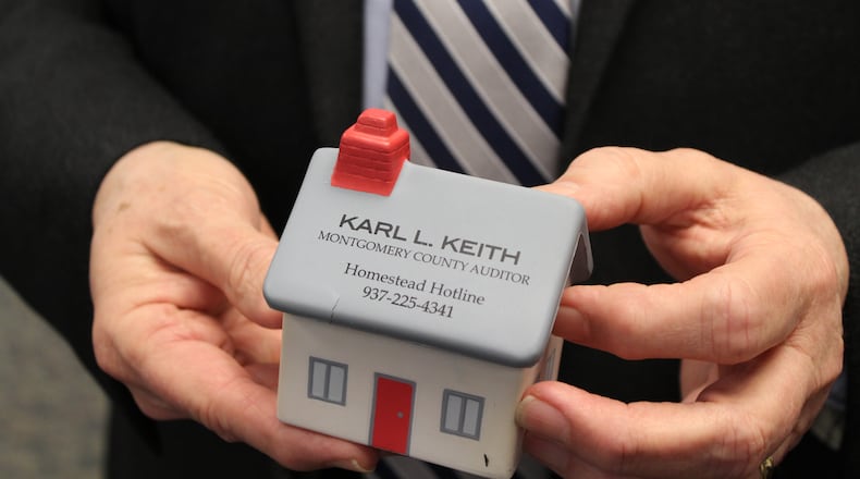 Montgomery County Auditor Karl Keith holds a foam desktop toy with the phone number citizens can call to learn more about the homestead exemption program. CORNELIUS FROLIK / STAFF