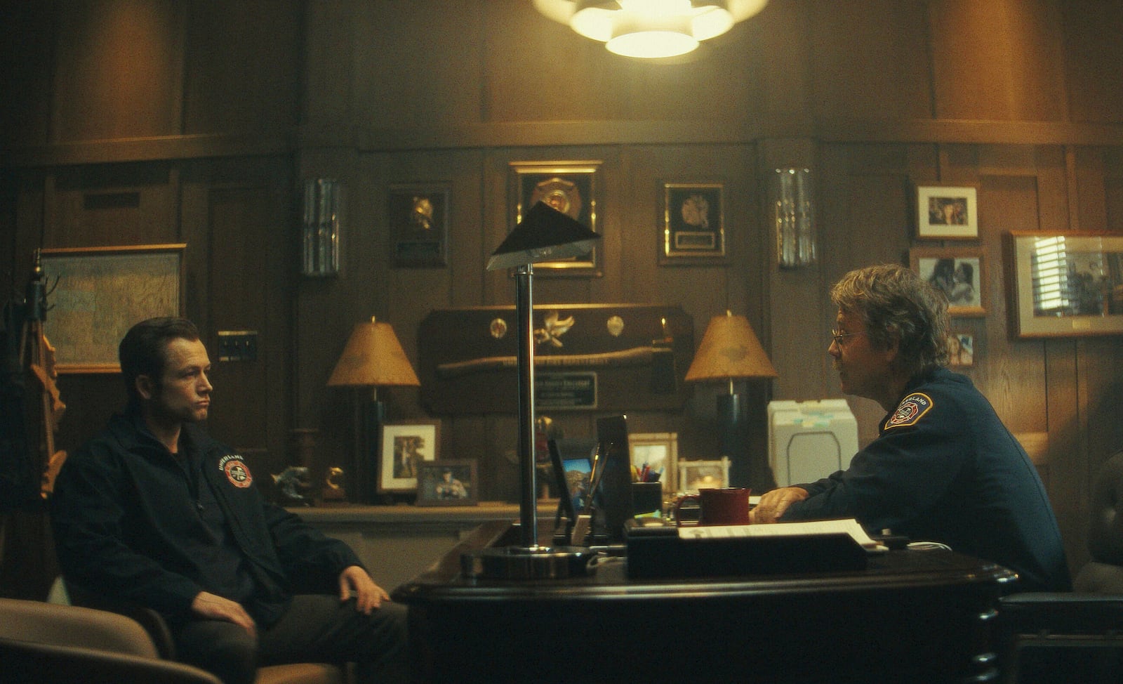 This image released by Apple TV+ shows Taron Egerton, left, and Greg Kinnear in a scene from "Smoke." (Apple TV+ via AP)