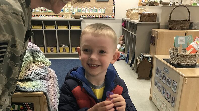 Liam Burger, 4, smiles and displays his purple ribbon in theWright-Patterson Air Force Base Child Development Center South. CDC staff handed out thepurple ribbons to military children in honor of their sacrifice during Month of the Military Child in April. (U.S. Air Force photo/Staff Sgt. Whitney Trimble)