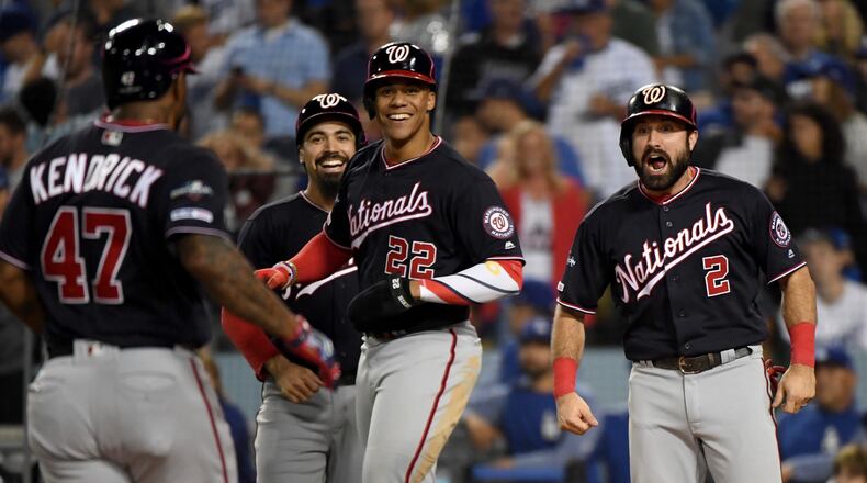 The Nationals' Howie Kendrick celebrates after hitting a grand slam with teammates Anthony Rendon, back left, Adam Eaton, right, and Juan Soto, center, in the tenth inning of game five of the National League Division Series against the Los Angeles Dodgers at Dodger Stadium on October 09, 2019 in Los Angeles, California. (Photo by Harry How/Getty Images)