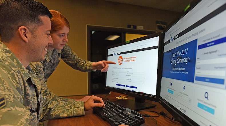 Airman 1st Class Holly Ardern, key worker for the Ohio Combined Federal Campaign, Miami Valley District, at Wright-Patterson Air Force Base, demonstrates features of the new campaign pledging website to Airman 1st Class Jean-Paul Arnaud-Marquez, 88th Air Base Wing Public Affairs, Oct. 16. (U.S. Air Force photo/Michelle Gigante)
