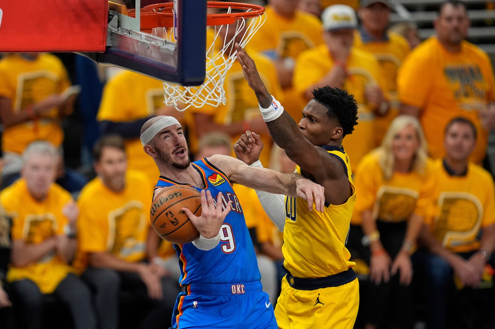 Oklahoma City Thunder guard Alex Caruso (9) drives on Indiana Pacers guard Bennedict Mathurin during the first half of Game 4 of the NBA Finals basketball series, Friday, June 13, 2025, in Indianapolis. (AP Photo/Abbie Parr)