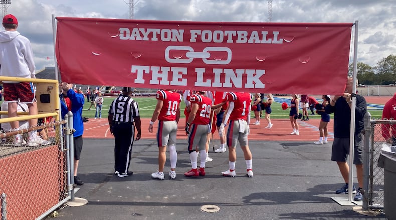 The Dayton football team prepares to take the field for a game against Presbyterian on Sept. 25, 2021, at Welcome Stadium. The Link sign refers to a tradition in which players carry chain links around with them on their keychains. David Jablonski/Staff