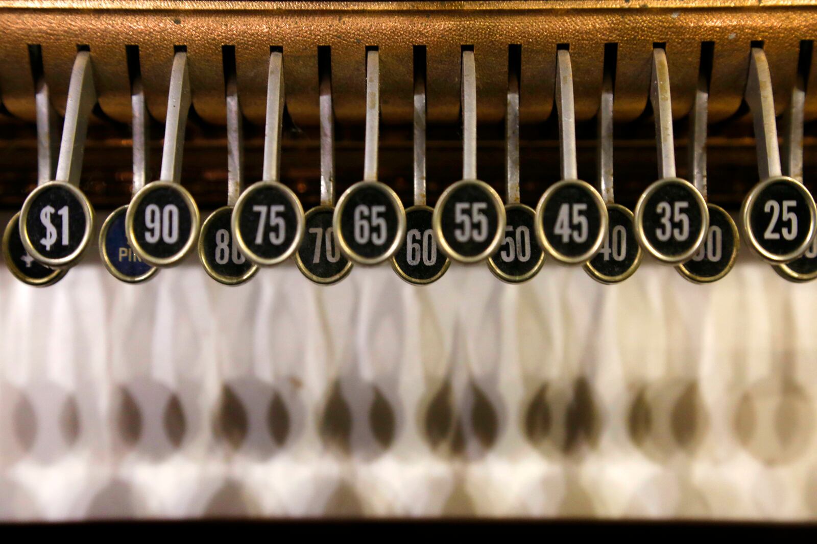 Inlayed wood cash register cabinets glow in shades of chestnut and ebony and elegant keys cast shadows on white marble. LISA POWELL / STAFF