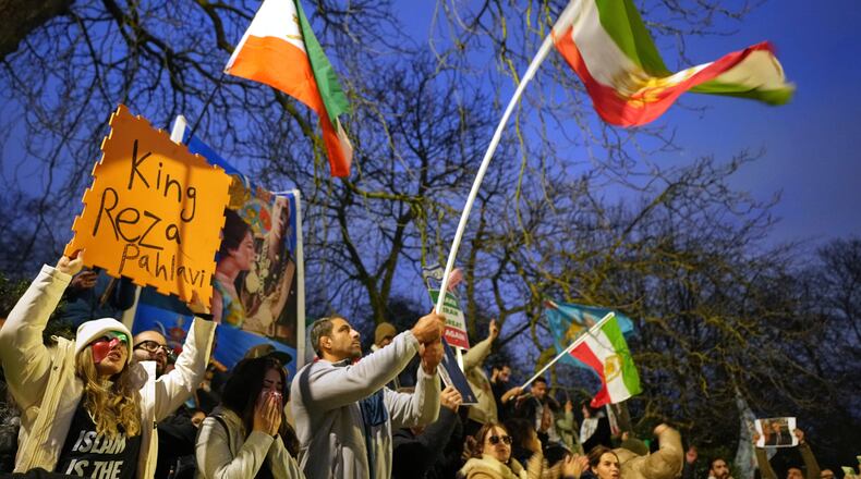 Protesters hold up placards and flags as they demonstrate outside the Iranian Embassy in London, Monday, Jan. 12, 2026. (AP Photo/Alastair Grant)