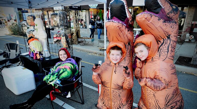 Carolyn Eldridge (left) smiles at her kids Reid (middle) and Morgan who were dressed up as dinosaurs at the second annual Monster Bash sponsored by Route 68 Vintage Toy Mall in Xenia in October. MARSHALL GORBY \ STAFF