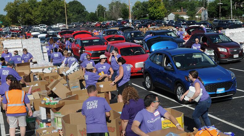 The Dayton Foodbank, Inc. along with nearly 200 volunteers from CareSource served over 1,000 families at the University of Dayton Arena Mass food distribution Tuesday Aug. 23, 2022. MARSHALL GORBY\STAFF