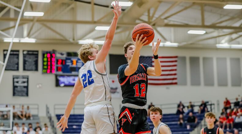 Versailles High School junior Jace Watren drives to the hoop against Mariemont senior Nolan Theye during their game on Wednesday night at Trent Arena in Kettering. The Tigers won 68-43. Michael Cooper/CONTRIBUTED