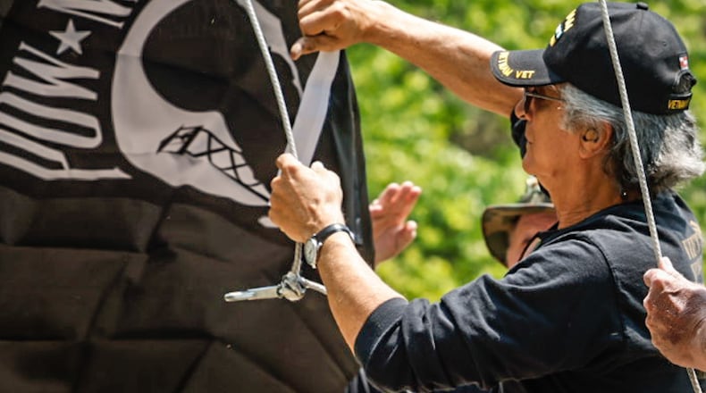 Vietnam veteran Mark Kucharski replaces the POW-MIA flag at the Vietnam Veterans Memorial Park in Dayton Friday May 19, 2023. JIM NOELKER/STAFF