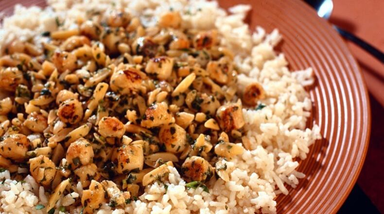 Scallops are sauteed, then mixed with lemon, almonds and garlic in a quick dinner that is yet complex and satisfying. (James F. Quinn/Chicago Tribune/TNS)