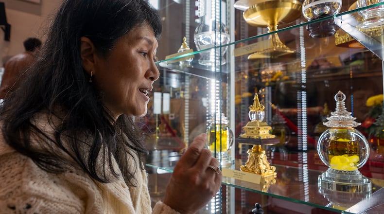 Buddhist practitioner and disciple of Master YongHua, Sarah Kim, shows the Fragrant Oil Shariras among other Buddhist relics displayed at Wei Mountain Temple, in Rosemead, Calif., Saturday, Feb. 17, 2024. (AP Photo/Damian Dovarganes)