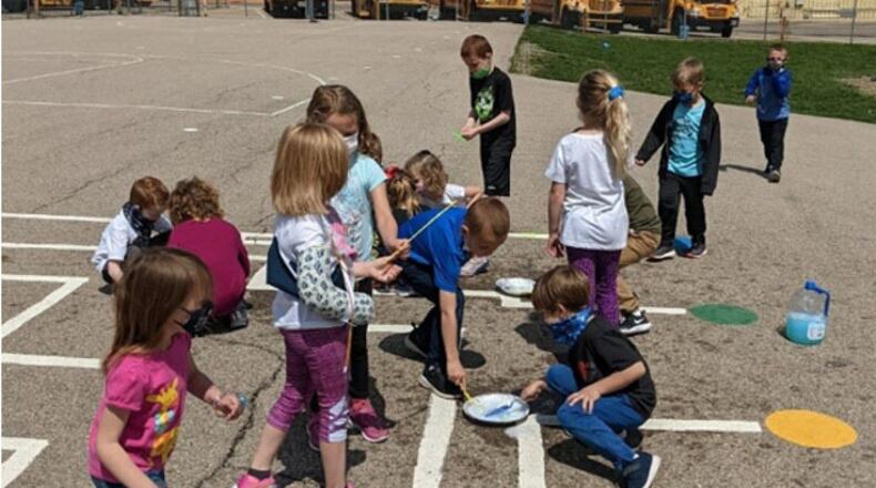 Students at Shaw Elementary School in Beavercreek learn about molecules, cohesion and surface tension using the “bubbles and water” lesson as part of the Wizards of Wright! presentation in April. (Contributed photo)