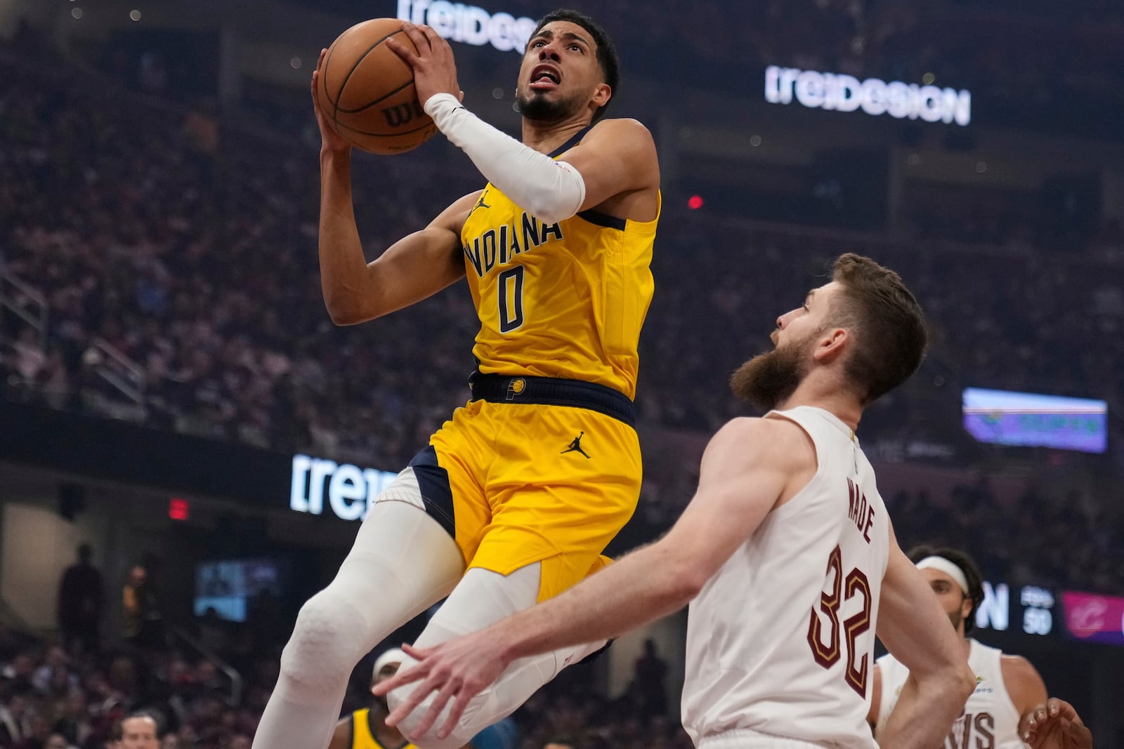 Indiana Pacers' Tyrese Haliburton (0) goes to the basket in front of Cleveland Cavaliers' Dean Wade (32) in the first half of Game 1 in the Eastern Conference semifinals of the NBA basketball playoffs Sunday, May 4, 2025, in Cleveland. (AP Photo/Sue Ogrocki)