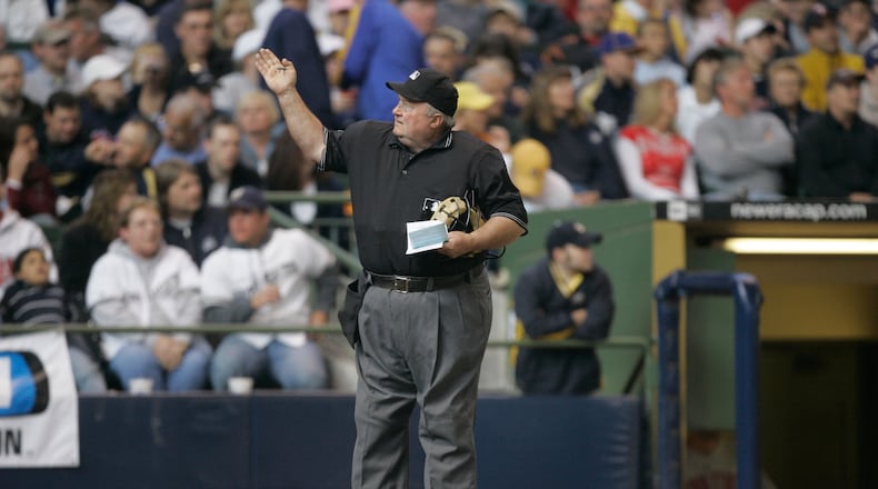 FILE - Home plate umpire Bruce Froemming signals to the official scorer during the fifth inning of a baseball game May 20, 2007, in Milwaukee. (AP Photo/Morry Gash, File)