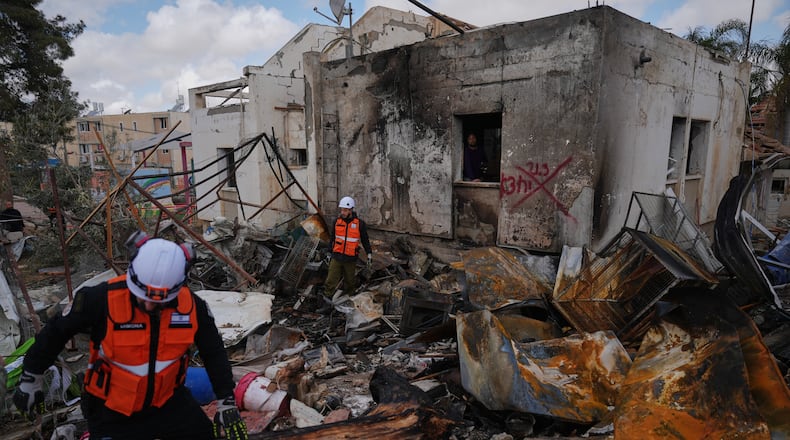 Israeli security forces survey the site that was struck by an Iranian missile in Dimona, southern Israel, Sunday, March 22, 2026. (AP Photo/Ariel Schalit)