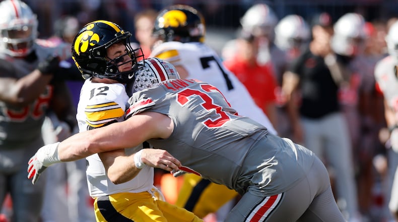 Ohio State defensive lineman Jack Sawyer, right, hits Iowa quarterback Cade McNamara after he throws a pass during the first half of an NCAA college football game, Saturday, Oct. 5, 2024, in Columbus, Ohio. (AP Photo/Jay LaPrete)