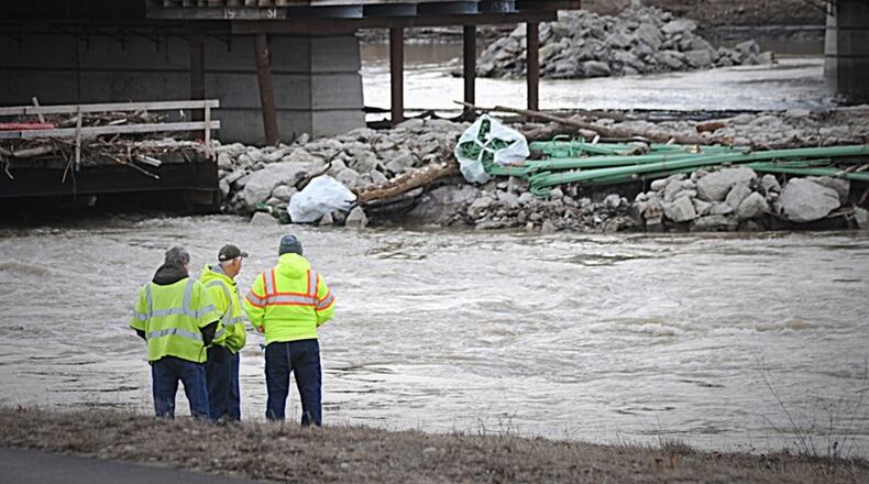 Crews along the banks of the river in Dayton. STAFF