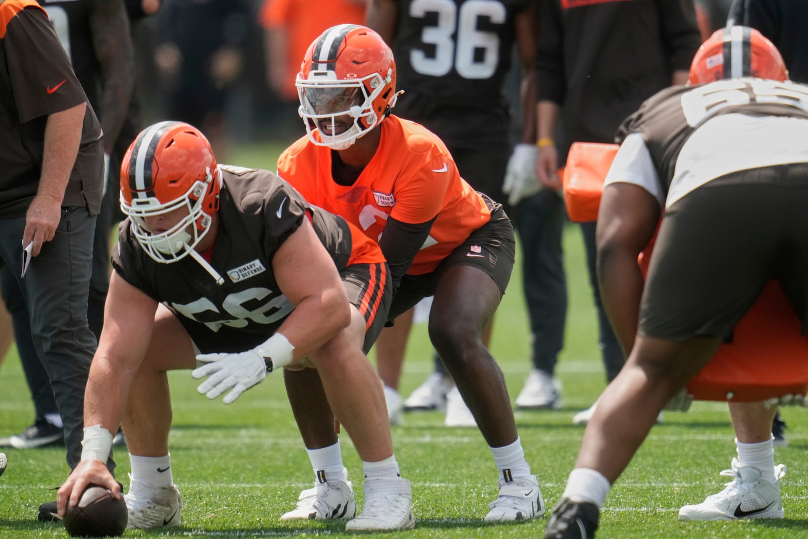 Cleveland Browns quarterback Shedeur Sanders, center, prepares to take the snap from center Luke Wypler (56) during practice at NFL football minicamp in Berea, Ohio, Tuesday, June 10, 2025. (AP Photo/Sue Ogrocki)