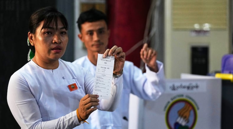 An official of the Union Election Commission shows a slip as they count ballots at a polling station during the second phase of general election in Yangon, Myanmar, Sunday, Jan. 11, 2026. (AP Photo/Thein Zaw)