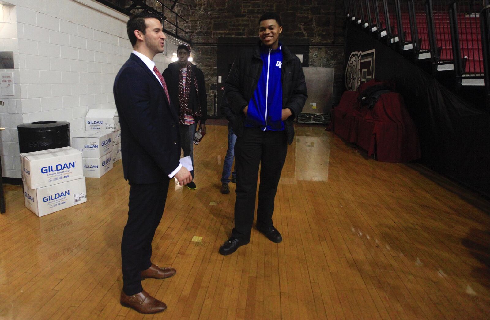 Dayton coach Brian Frank, left, talks to 2017 recruit Jordan Pierce after a victory at Fordham on Jan. 31, 2017.