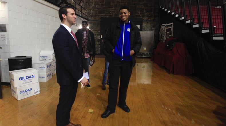 Dayton coach Brian Frank, left, talks to 2017 recruit Jordan Pierce after a victory at Fordham on Jan. 31, 2017.