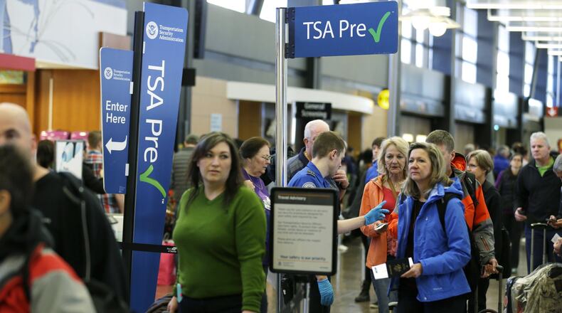 FILE - In this March 17, 2016, file photo, travelers authorized to use the Transportation Security Administration’s PreCheck expedited security line at Seattle-Tacoma International Airport in Seattle have their documents checked by TSA workers. Service members are already enrolled in TSA Precheck, but many do not know they are. (AP Photo/Ted S. Warren)