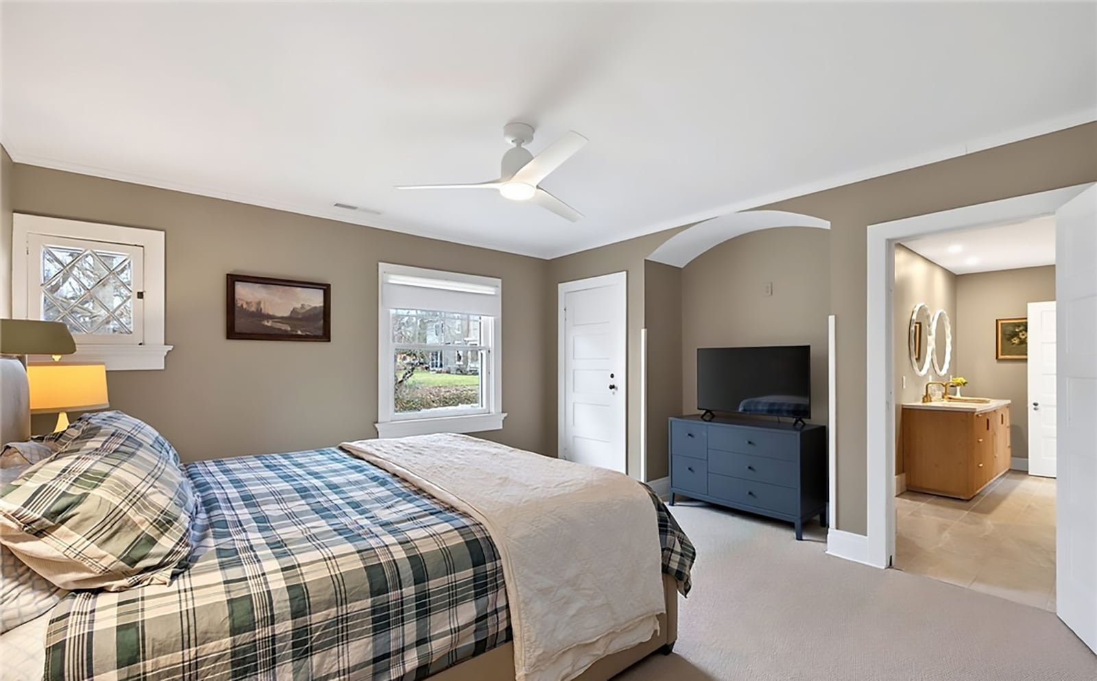 The second floor primary bedroom suite has neutral carpeting, a ceiling fan and crown molding. the ensuite bathroom has a new vanity, tile flooring and updated walk in shower. CONTRIBUTED