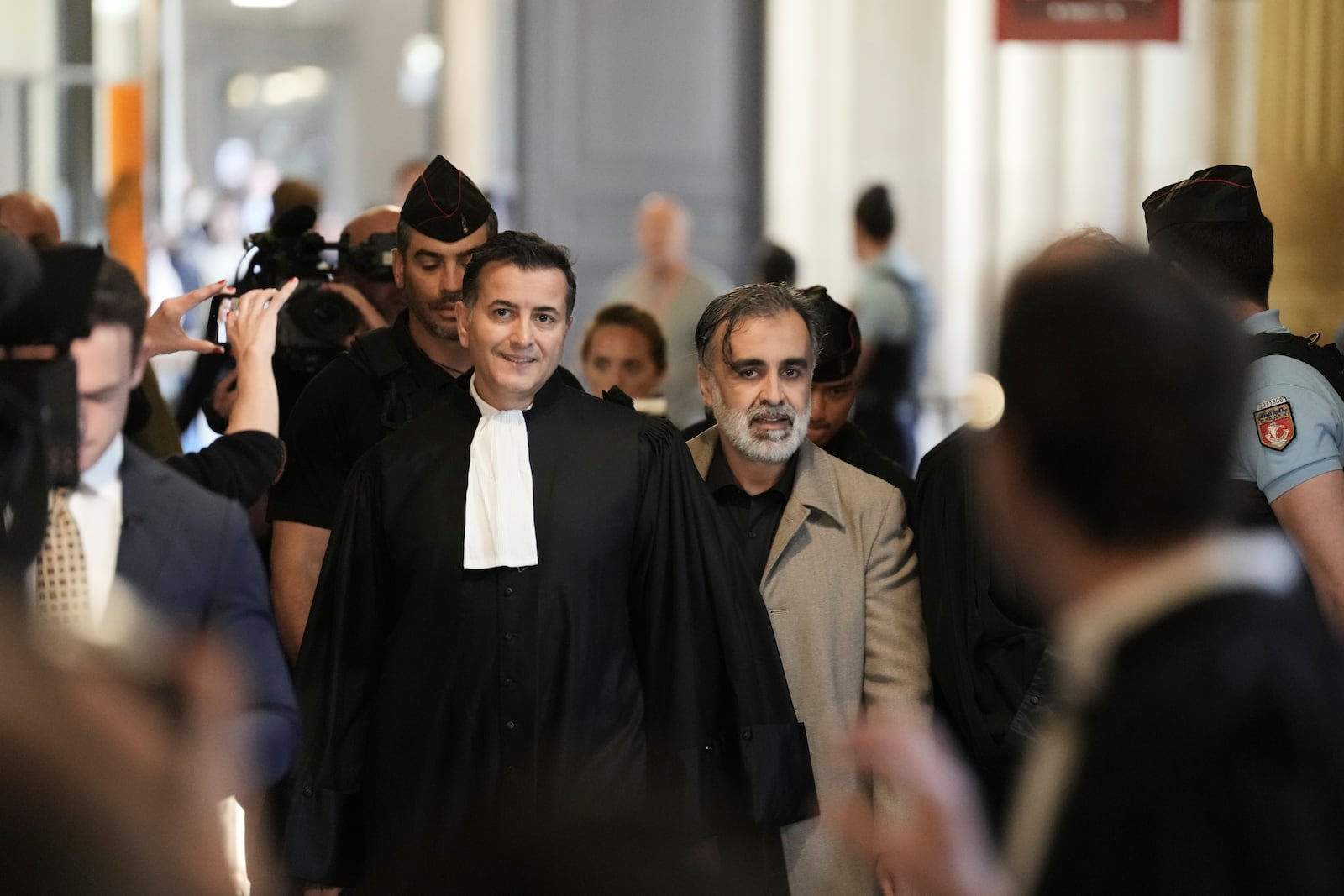 Abderrahmane Ouatiki, center right, who was working as a hotel receptionist, is accompanied by his lawyer Mohand Ouidja, center left, as they arrive for the trial of the 2016 armed robbery of Kim Kardashian, at the palace of justice, Tuesday, May 13, 2025 in Paris. (AP Photo/Aurelien Morissard)